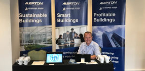 Mark Sutton sitting at AA/LEA Booth at the IHEA NSW ACT Branch Conference 2018